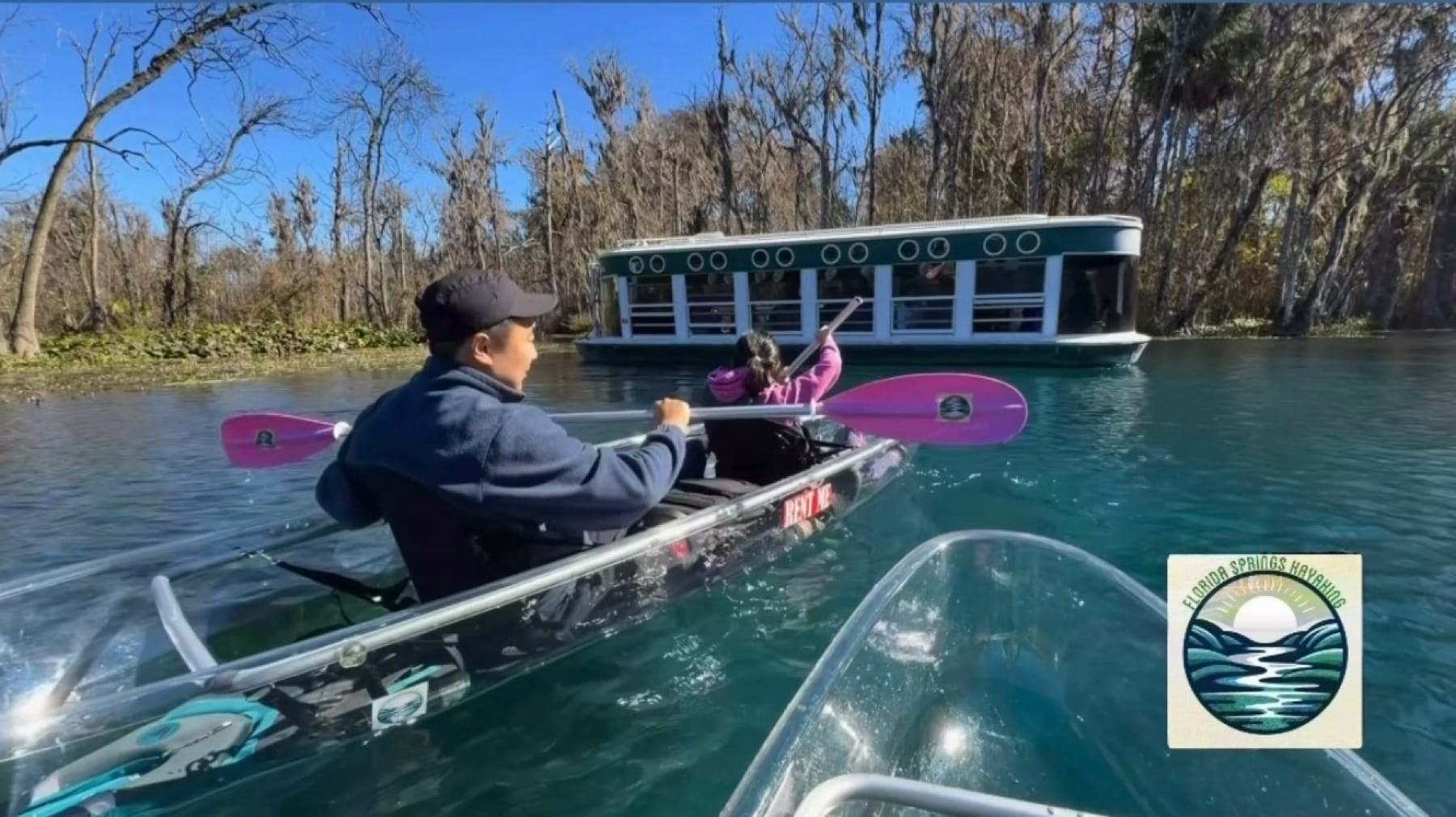 A clear kayak with pink paddles near the Silver Springs glass-bottom boat